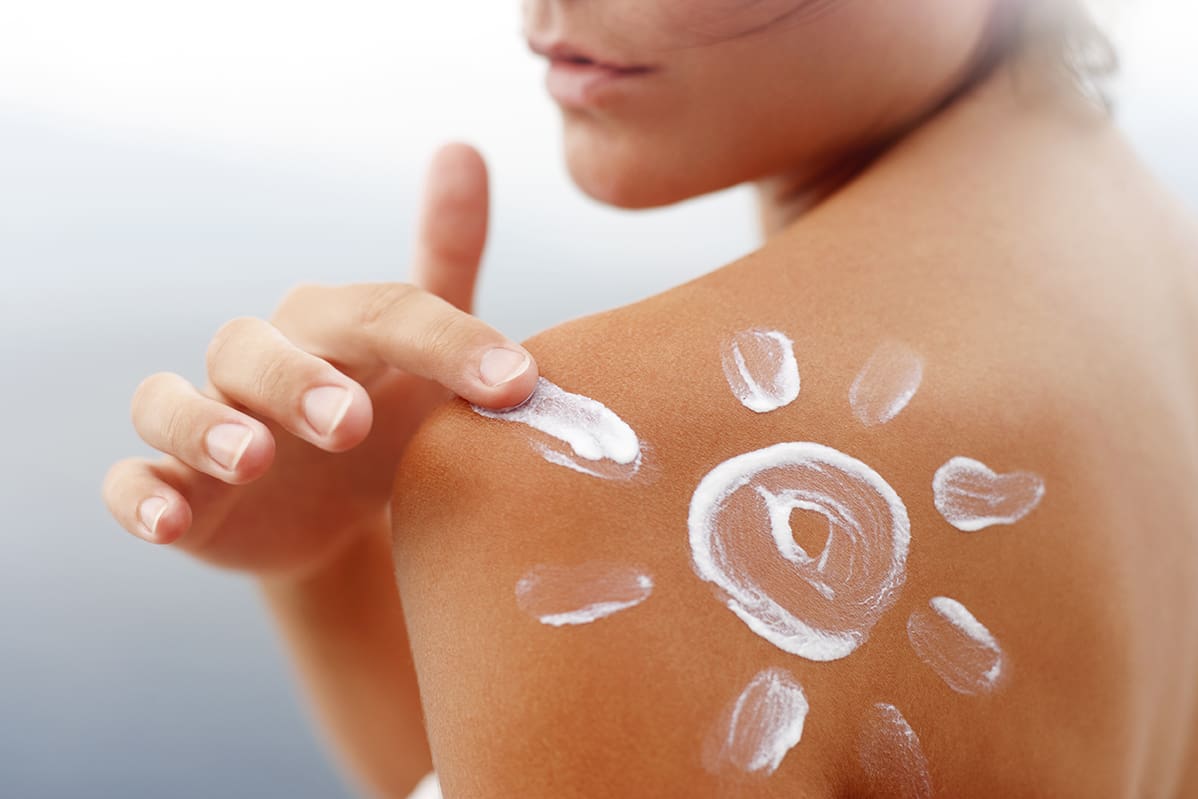 Dark,Tanned,Body,In,Summer women putting sunscreen on her