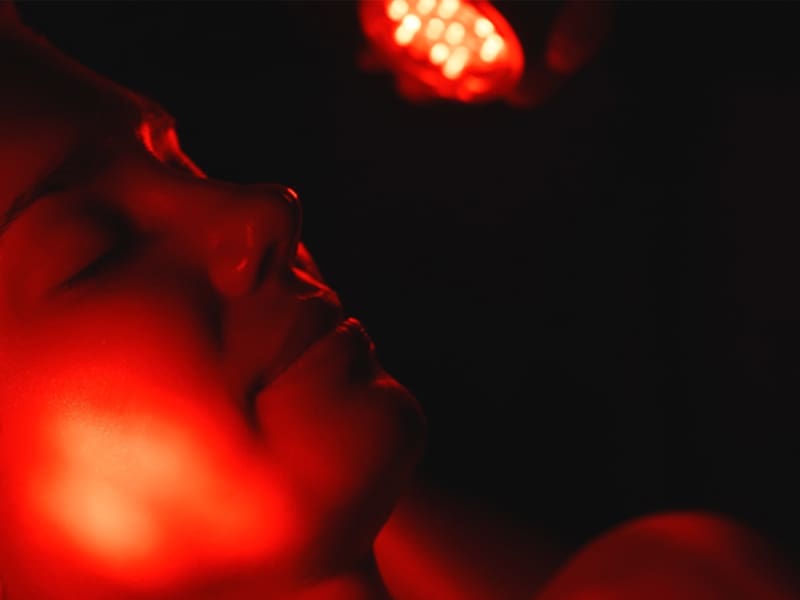 LM-red-light-therapy-for-skin close-up of woman's face during red light therapy