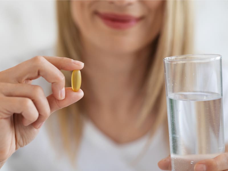 LM-best-menopause-supplements-for-weight-loss v2 woman holding a tablet and a glass of water to illustrate best menopause supplements for weight loss